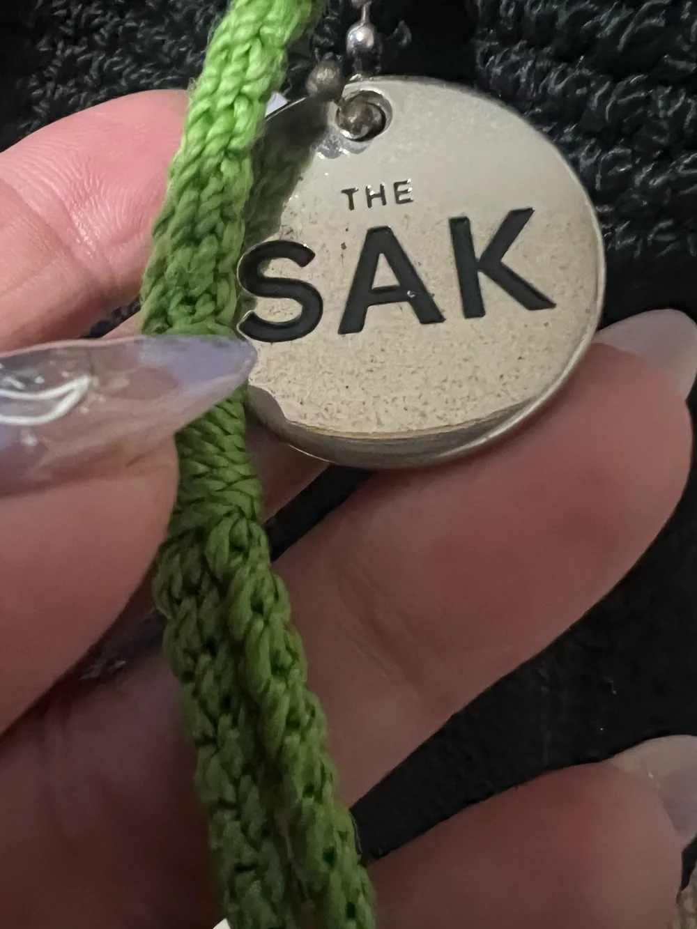 The Sak Black Knit Drawstring Backpack with Pink Floral Charm